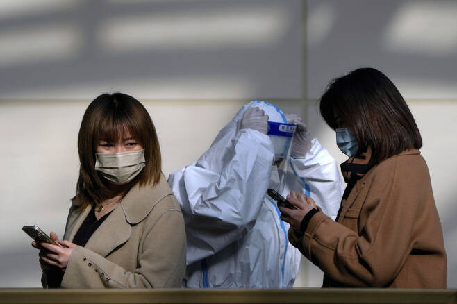 2022년 12월5일(현지 시각) 베이징시의 한 코로나19 검사소에서 마스크를 쓴 여성들이 검사를 받기 위해 줄을 서고 있다. ⓒAP=연합