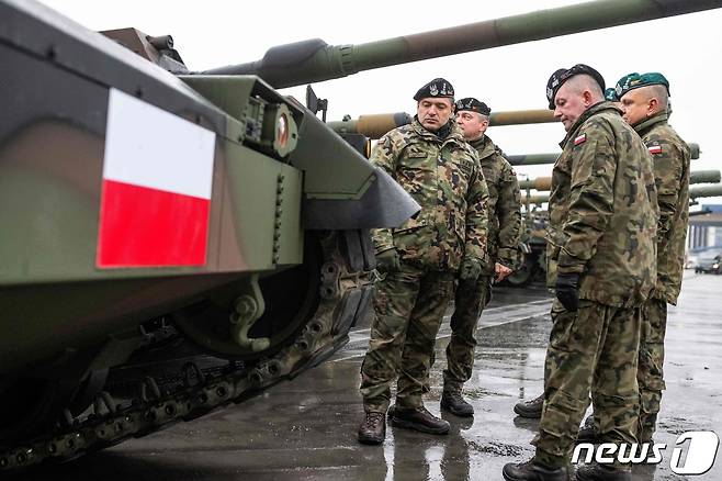 6일(현지시간) 폴란드 그디니아 항구에 한국산 K2 전차와 K9자주포가 처음 입고됐다. 군인들이 폴란드 국기가 전차 앞을 지키고 있다.. ⓒ AFP=뉴스1 ⓒ News1