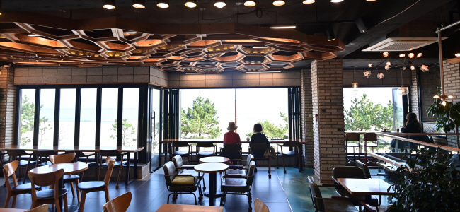 망상해수욕장의 베이커리 카페 ‘클램’ 2층에서는 백사장 너머의 바다를 정면으로 바라볼 수 있다.