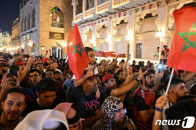 (도하 AFP=뉴스1) 김성식 기자 = 모로코 축구 팬들이 6일(현지시간) 카타르 도하의 수크 와키프 시장에 모여 2022 카타르 월드컵 16강전 승리를 자축하고 있다. 이날 모로코는 승부차기 끝에 스페인을 상대로 극적인 승리를 거둬 8강에 진출한다. ⓒ AFP=뉴스1 Copyright (C) 뉴스1. All rights reserved. 무단 전재 및 재배포 금지.