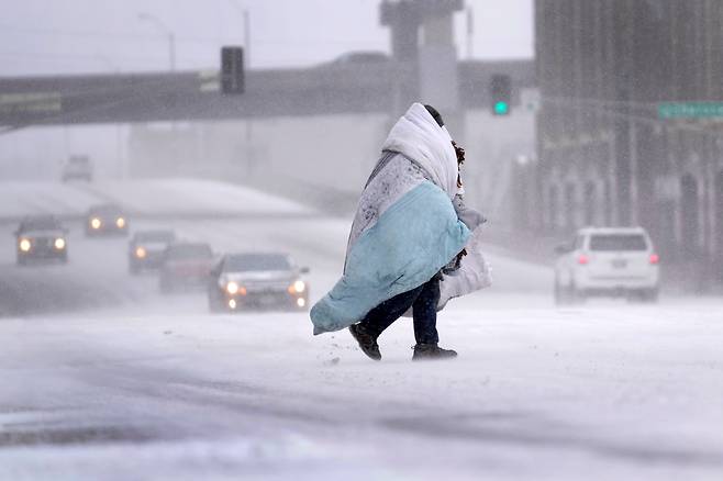 지난 22일 미국 미주리주 세인트루이스에서 한 시민이 담요를 뒤집어 쓴 채 걷는 모습. /AP 연합뉴스
