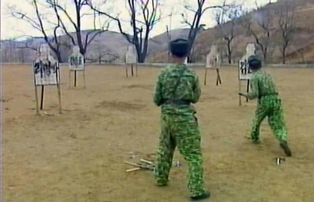 북한의 군인들이 2012년 3월 이명박 당시 대통령의 실명이 적혀 있는 표적판에 칼과 도끼 등을 던지고 있는 모습. 연합뉴스