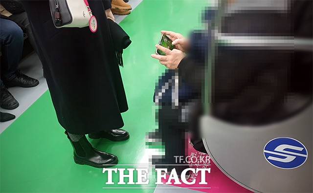 8개월 차 임신부가 10일 오후 지하철 2호선 임산부 배려석 앞에 서 있다. 게임하는 임산부석 일반 승객. /이덕인 기자