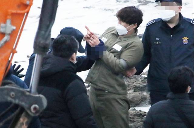 택시 기사와 동거녀를 살해한 혐의로 구속된 이기영이 6일 오후 경기 파주 공릉천변에서 검찰 관계자들에게 시신을 매장했다고 진술한 부근을 손으로 가리키고 있다. 연합뉴스 캡처