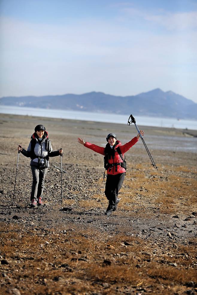 앞장술해변의 드넓은 갯벌을 즐기는 나해란씨와 박자희(오른쪽)씨. 나들길 12코스는 앞장술해변을 따르다 주문도리의 서도중앙교회로 이어진다. 바다 건너 석모도 해명산이 긴 능선을 드러내고 있다.