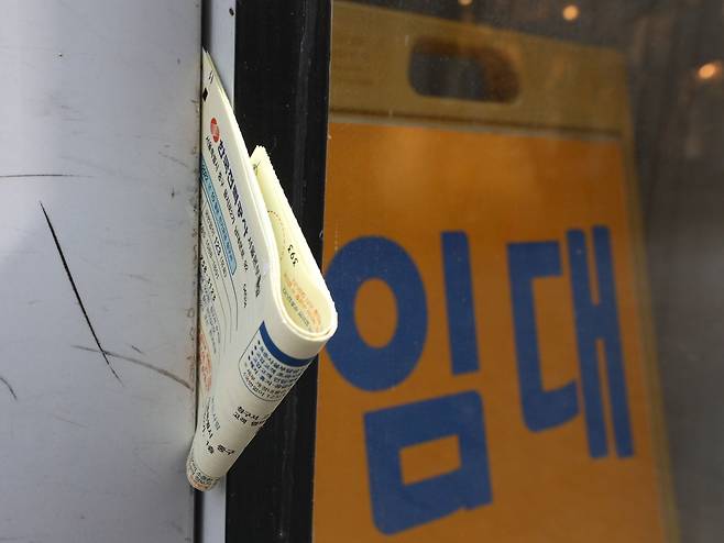 서울 중구 명동거리의 한 상가의 폐업 안내 옆 전기 고지서가 놓여 있다. /뉴스1