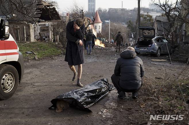 [키이우=AP/뉴시스]2022년 12월31일(현지시간) 우크라이나 수도 키이우에서 러시아의 공격으로 사망한 아내의 시신 옆에서 한 남자가 비통해하고 있다. 2023.01.01