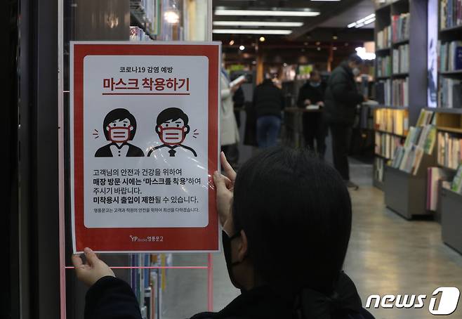 서울의 한 대형 서점에서 직원이 마스크 착용 안내문을 떼고 있다./뉴스1 ⓒ News1 신웅수 기자