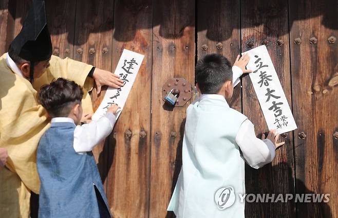 다가오는 입춘 (울산=연합뉴스) 김용태 기자 = 입춘을 이틀 앞둔 2일 오전 울산시 중구 울산향교에서 유림이 아이들과 함께 입춘첩을 붙이고 있다. 2023.2.2 yongtae@yna.co.kr