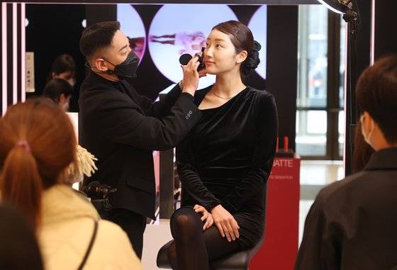 실내 마스크 착용 의무 해제로 백화점과 화장품 업체들이 각종 시연 행사를 열고 고객을 맞기 위한 준비에 나섰다. 1일 서울 영등포구 더현대 서울에서 열린 메이크업 쇼에서 관계자가 제품을 시연하고 있다. 연합뉴스