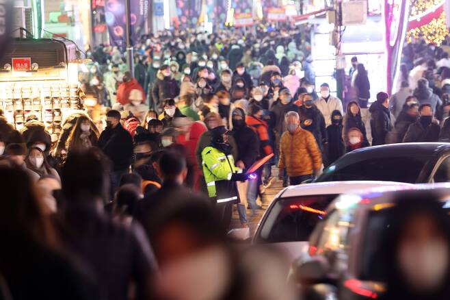 크리스마스 이브인 지난해 12월 24일 경찰이 연말 분위기를 즐기는 시민과 차량으로 붐비는 서울 명동거리를 통제하고 있다./연합뉴스