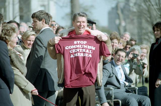 '중미 공산주의 저지'라는 문구를 새긴 티셔츠를 들어 보이는 1986년 3월의 로널드 레이건. 위키미디어 커먼스