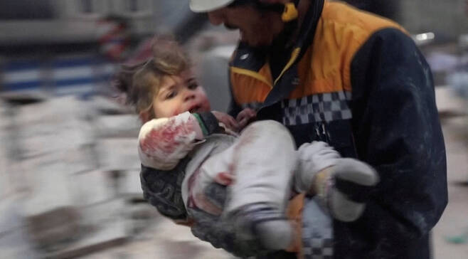 6일(현지시간) 시리아 반군이 장악한 아자즈에서 구조대원이 건물 잔해에서 부상당한 아이를 옮기고 있다. 로이터연합뉴스