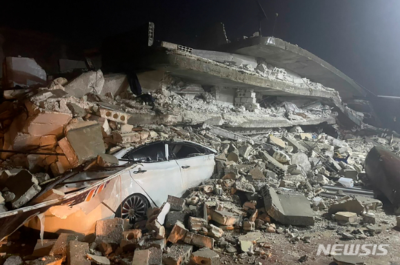 6일(현지시간) 시리아 북부 이들리브주 아즈마린 마을에서 무너진 건물 잔해 사이로 파손된 차량 한 대가 보이고 있다. 이날 튀르키예 남동부와 시리아에서 규모 7.8의 강진이 발생해 수백명의 사상자가 발생한 것으로 전해졌다. 이날 튀르키예 여러 지방에서 피해가 보고됐고, 구조대가 현장에 파견됐다. [사진=아즈마린=AP/뉴시스]