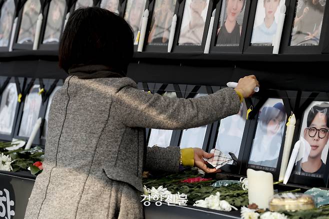 이태원 참사 유가족들이 6일 시청 앞 서울광장에 마련된 10·29 이태원 참사 희생자 합동분향소에서 영정사진이 담긴 액자를 손수건으로 닦고 있다. 문재원 기자