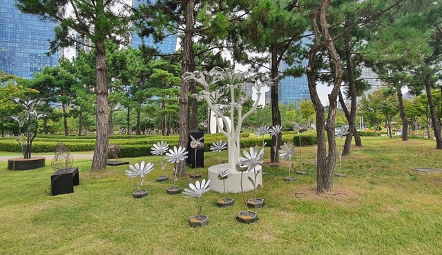 포스코건설이 작가들과 함께 폐자원으로 제작해 인천 송도 센트럴파크 공원에 전시한 꽃과 꿀벌 조형물. 포스코건설 제공