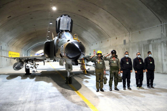 7일(현지시간) 이란 군 당국이 배포한 사진에서 이란 모처에 구축돼 ‘이글 44’로 명명된 지하 공군기지에 근무하는 파일럿들이 전투기 앞에서 경례를 하고 있다. 로이터·연합뉴스