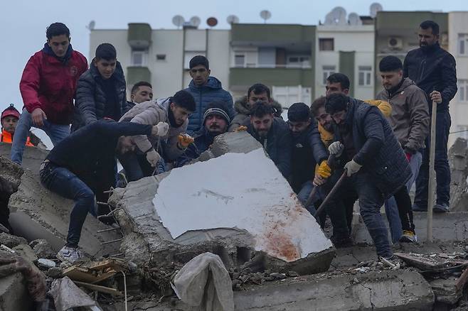 6일(현지시간) 튀르키예 남부 아다나에서 실종자 수색에 나선 시민들이 강진으로 붕괴한 건물 잔해를 들어올리고 있다. 이날 튀르키예에서는 규모 7.8, 7.5의 강진이 잇따라 발생하고 80여 차례 여진이 일어나 건물 5600여 채가 붕괴했다. 시리아와 국경을 맞댄 지역에서 일어난 이번 지진으로 튀르키예와 시리아에서 현재까지 약 3500명이 사망했다. 2023.02.07 / 사진=AP 연합뉴스