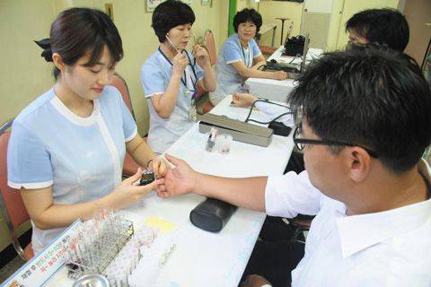 직장인들이 건강검진센터를 찾아 혈당을 측정하고 있다. /종근당