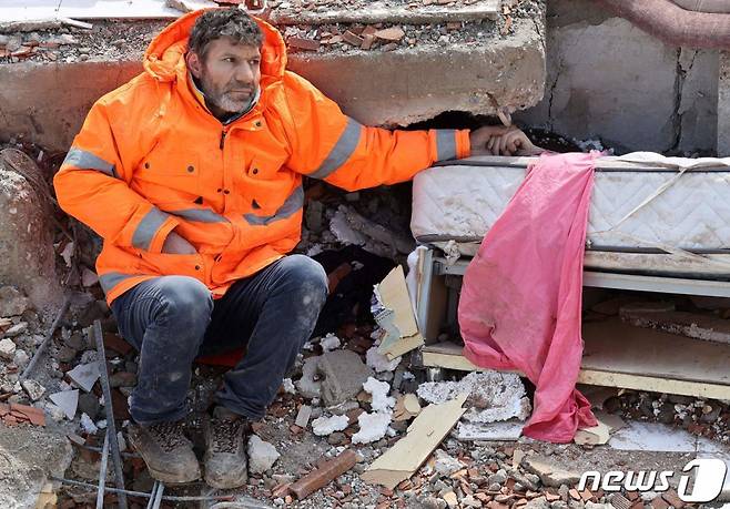 (카라만마라슈 AFP=뉴스1) 우동명 기자 = 7일 (현지시간) 강진이 강타한 튀르키예 카라만마라슈에서 아버지가 무너진 건물 잔해에 깔려 숨진 15세 딸의 손을 꼭 잡고 있다. ⓒ AFP=뉴스1 Copyright (C) 뉴스1. All rights reserved. 무단 전재 및 재배포 금지.