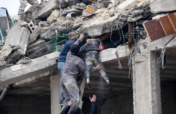 튀르키예 남동부와 시리아 북서부에서 규모 7.8과 7.5의 강진이 잇따라 발생한 6일(현지시간) 시리아 북서부의 알레포주 아프린시 잔다리스의 시민들이 붕괴된 건물에 갇혀 있던 여자아이를 구조하고 있다. 잔다리스 AFP 연합뉴스