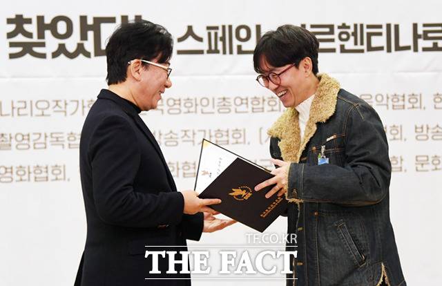 한국영화감독조합 대표인 윤제균 감독(왼쪽)이 9일 오전 서울 여의도 국회 의원회관에서 열린 '영상저작자의 정당한 보상! 저작권법 개정안 지지 선언회'에서 장항준 감독에게 저작권료를 수여하고 있다.