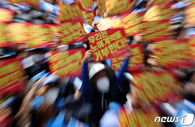 민주노총 서비스연맹 전국택배노동조합원들이 13일 오전 서울 세종대로 광화문사거리 일대에서 열린 '임금삭감, 쉬운 해고 노예계약 저지' 우체국 택배 노동자 총력 결의대회에서 노예계약서를 거부하며 손 피켓을 들고 있다. 2022.6.13/뉴스1 ⓒ News1 이동해 기자