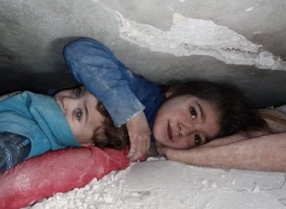 튀르키예 남부에서 발생한 최악의 지진으로 5200명 이상의 사망자가 속출한 가운데 온라인상에서는 잔해에 깔린 채 동생을 지키고 있는 소녀의 영상이 퍼졌다. 사진@AlmosaZuher 트위터 캡처