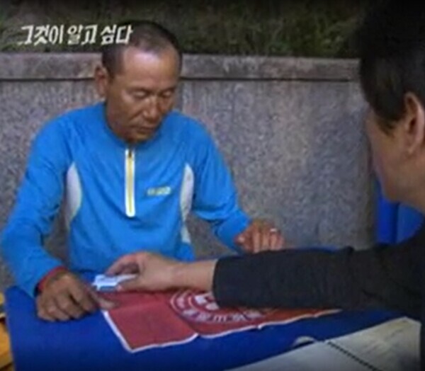 '그것이 알고 싶다'에서 박준우 PD에게 자신이 직접 주웠다고 하는 수원대 깃발을 전달하며 인터뷰 중인 김재수 대장. 사진 SBS VOD.
