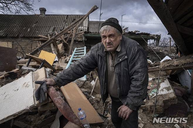 [막시밀리니우카=AP/뉴시스] 21일(현지시간) 우크라이나 막시밀리니우카 마을 주민이 러시아의 로켓 공격으로 파괴된 집 잔해 속에서 무언가를 찾고 있다. 2023.02.22.