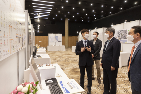 A UOS student explains his work to Suh at the school’s annual exhibition of urban sciences graduation projects held on campus in 2021. [UNIVERSITY OF SEOUL]