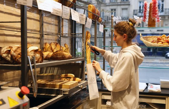 유럽에서 설탕·밀가루·버터 등 빵에 들어가는 주요 품목 가격이 사상 최고치로 치솟고 있다. 프랑스 파리의 한 빵집에서 직원이 바게트를 봉지에 넣는 모습. 신화=연합뉴스
