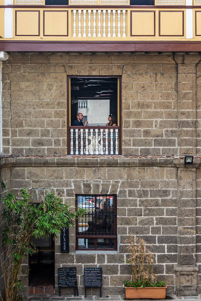 탈라 바에서 까사 마닐라를 바라보며 차를 마시는 여행자