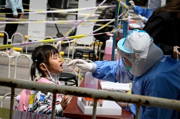 중국 수도 베이징 거리의 코로나19 임시 검사소에서 의료진이 한 어린이의 검체를 채취하고 있다. 사진=연합뉴스