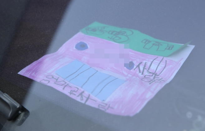 18일 인천시 미추홀구 한 주택에서 숨진 채 발견된 일가족 소유 차량에 아이가 그린 것으로 보이는 종이가 놓여 있다. /사진=연합뉴스