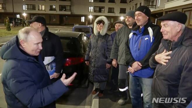 [AP/뉴시스] 러시아 TV 풀사진으로 19일 푸틴 러시아 대통령이 우크라이나 점령지 도네츠크주 마리우폴을 방문해 주민들과 말하고 있다