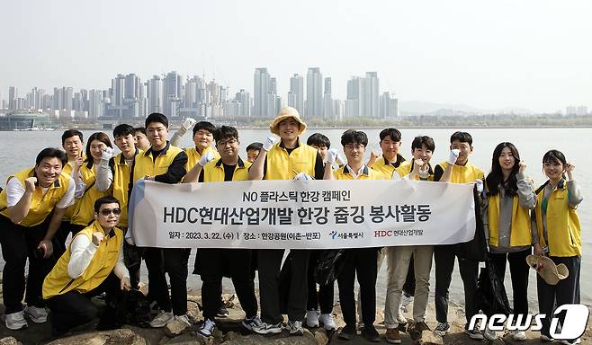 HDC현대산업개발 임직원들이 이촌-반포 일대 환경을 정비하기 위한 한강 줍깅 봉사활동에 참여해 기념사진을 촬영하고 있다..(HDC현대산업개발 제공).