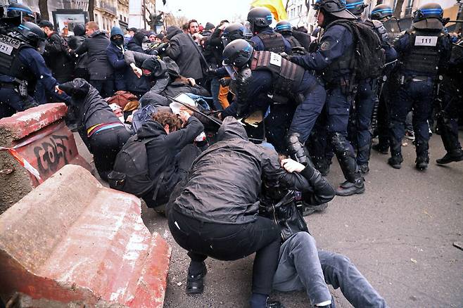 프랑스 연금개혁 반대 시위대가 23일(현지시각) 파리에서 열린 시위 도중 경찰과 충돌하고 있다. 파리/로이터 연합뉴스