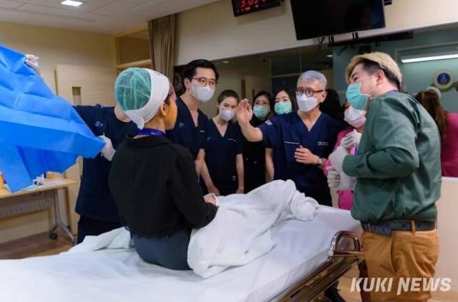 태국 Siriraj 병원에서 개최된 지방을 이용한 치료에 대한 워크숍에서 경피증의 후유증으로 얼굴이 함몰된 환자를 자가지방이식술로 치료하기 전에정기양 박사가 현지 의료진에게 설명하고 있다.