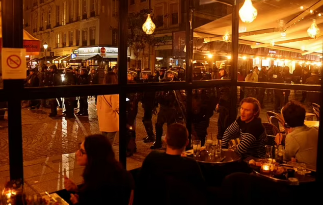 연금개혁 반대를 외치는 시위대를 진압하기 위해 모인 경찰들 곁으로 술집에서 술을 마시는 등 평범한 일상을 보내는 프랑스 시민들의 모습을 볼 수 있다. 로이터 연합뉴스