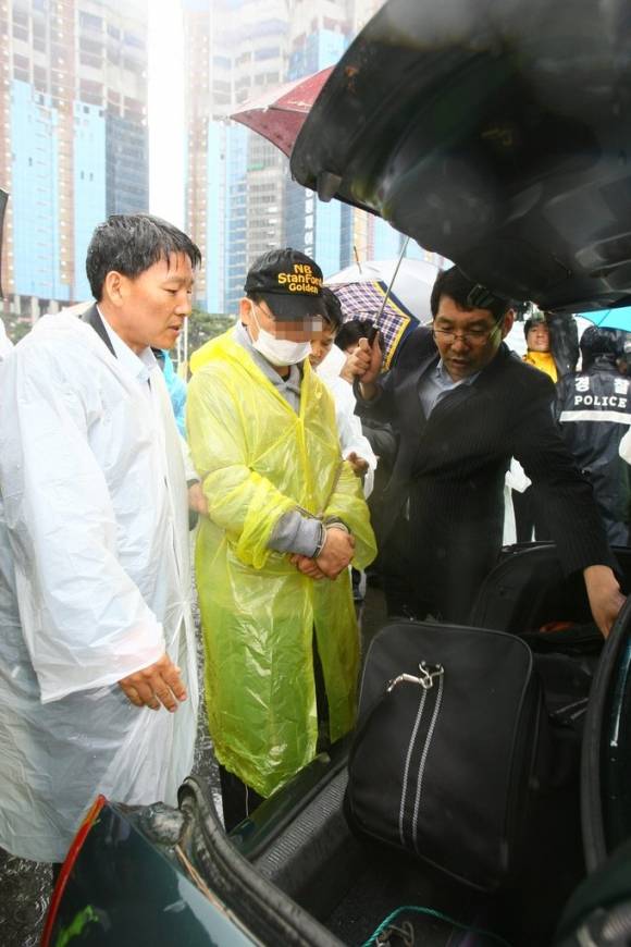 강씨가 아내를 살해한 부산 해운대구 모 호텔 인근 주차장에서 범행을 재연하고 있다. - 연합뉴스