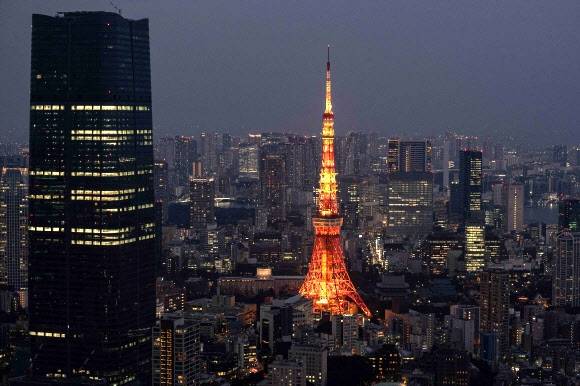 일본 도쿄에서 공사 중인 아자부다이 힐스 모리 JP 타워(왼쪽) 옆으로 도쿄타워(가운데)가 불을 밝히고 있다. 2023.2.8 AFP 연합뉴스