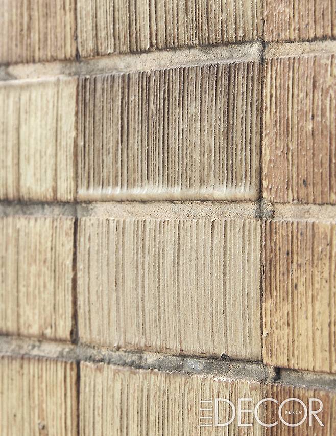 건물의 전면부와 측면부 외벽을 장식한 황색의 스크래치 타일.