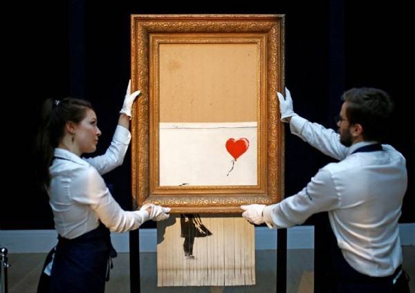 분쇄기에 의해 절반가량 잘려나간 뱅크시의 작품 '풍선과 소녀'. 로이터=연합뉴스