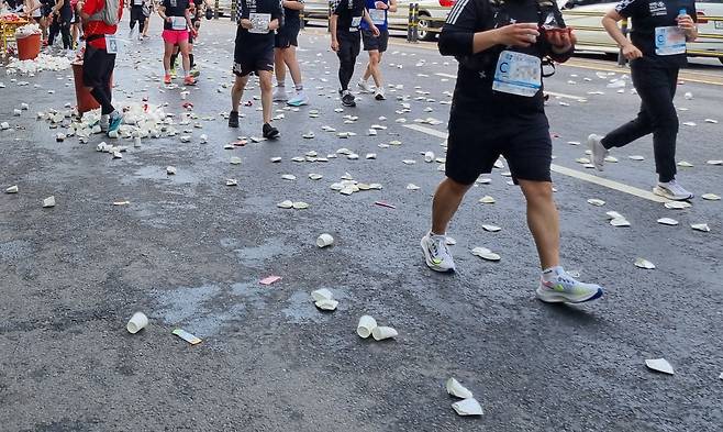 지난 주말 마라톤 대회 참가자들이 지나가는 도로에 일회용 종이컵이 버려져 있다. 김상수 기자