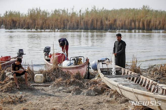 [바그다드(이라크)=AP/뉴시스] 이라크 티그리스강과 유프라테스강의 수위가 낮아지면서  디카르주의 농부들이 가축에 먹일 물을 폐선에서 길어 모으고 있다.