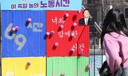 민주노총 조합원들이 3월22일 서울 청계천 한빛광장에서 인근 직장인을 대상으로 정부 근로시간 69시간 개편안 찬반 설문조사와 공 던지기를 하고 있다. 신소영 기자 viator@hani.co.kr