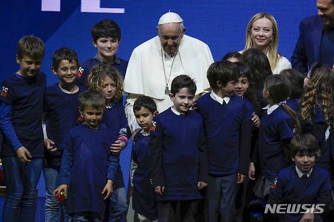 [AP/뉴시스] 교황 프란치스코와 이탈리아의 조르자 멜로니 총리가 12일 인구위기 회의가 끝난 뒤 아이들에 둘러싸여 사진을 찍고 있다
