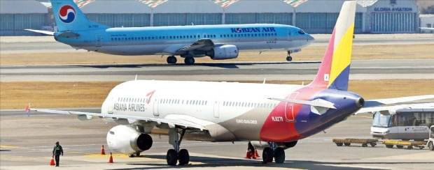 미국 법무부가 대한항공의 아시아나항공 인수 승인을 위해선 ‘아시아나급 경쟁자를 시장에 진입시켜야 한다’는 조건을 내걸었다. 사진은 김포공항에 세워진 아시아나 항공기 뒤로 대한항공 여객기가 착륙하고 있는 모습. 연합뉴스