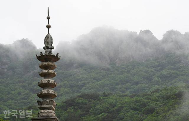 내장사 대웅전 자리에 놓인 석탑 뒤로 내장산 서래봉 바위 능선이 우람하다.